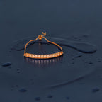 Rose gold crystal-bar adjustable bracelet with box chain and pearl accent, flat-lay close-up