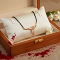 Necklace with black beads and a rose gold clasp on a light gray background