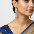 Rose gold cascading linear earrings with CZ floral arcs and teardrop, worn on model's ear