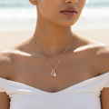 Rose gold-tone dual teardrop pendant necklace worn on neck, close-up on-model shot