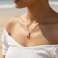 Rose gold swan crystal pendant necklace with delicate box chain, worn on-model at the beach showing wearable length