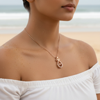 Rose gold ribbon crystal pendant necklace worn on neck at beach, close-up on-model shot