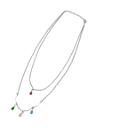 Silver-tone double-layer necklace with ruby, emerald, blue and pink teardrop crystal charms, flat-lay on black background