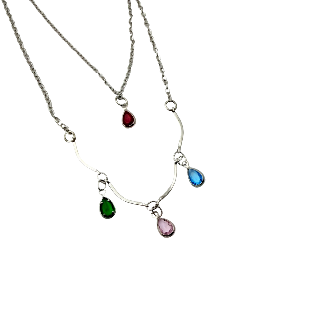 Silver-tone layered necklace with pastel teardrop crystal charms, close-up detail of chain and charm drops