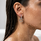Silver-tone crystal-studded interlocking drop hoop earring, close-up on-ear shot
