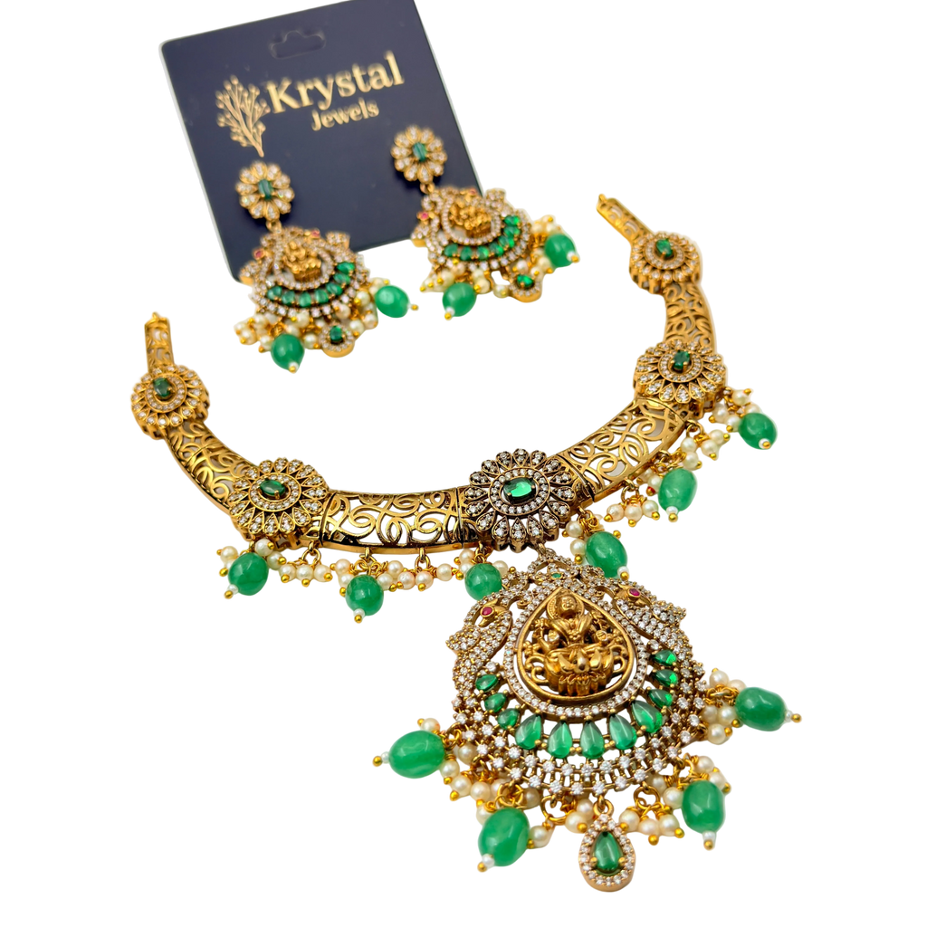 Gold and green jewelry set with 'Krystal Jewels' card on a white background