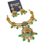 Gold and green jewelry set with 'Krystal Jewels' card on a white background