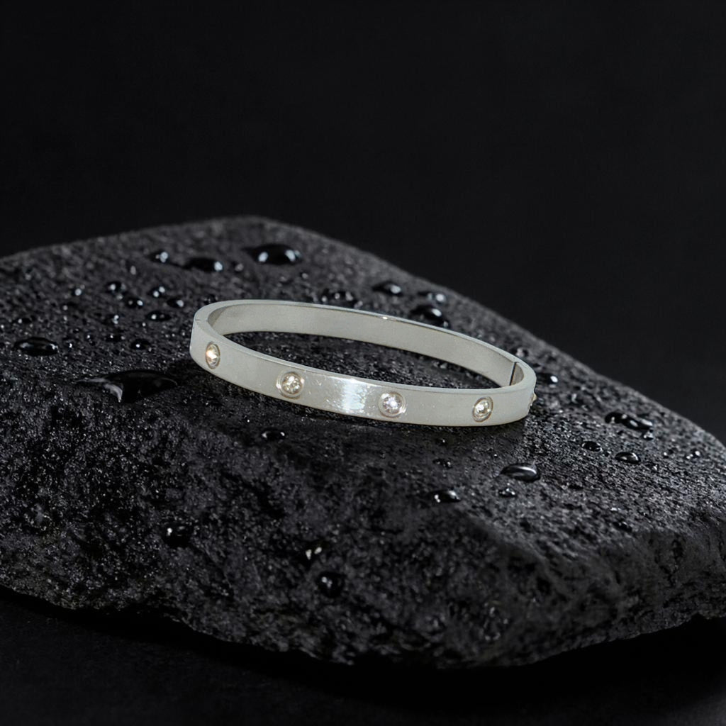 Silver bracelet with small stones on a black textured surface