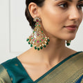 Pair of ornate earrings with green and pink stones