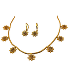 Gold necklace and earrings set on a white background