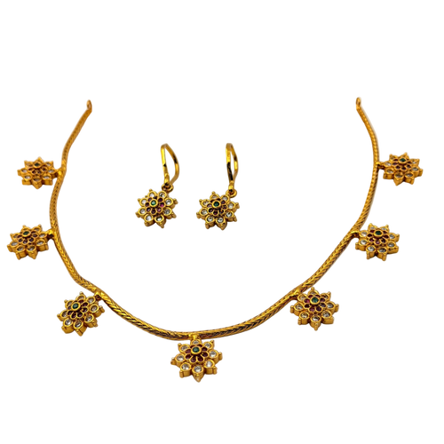 Gold necklace and earrings set on a white background