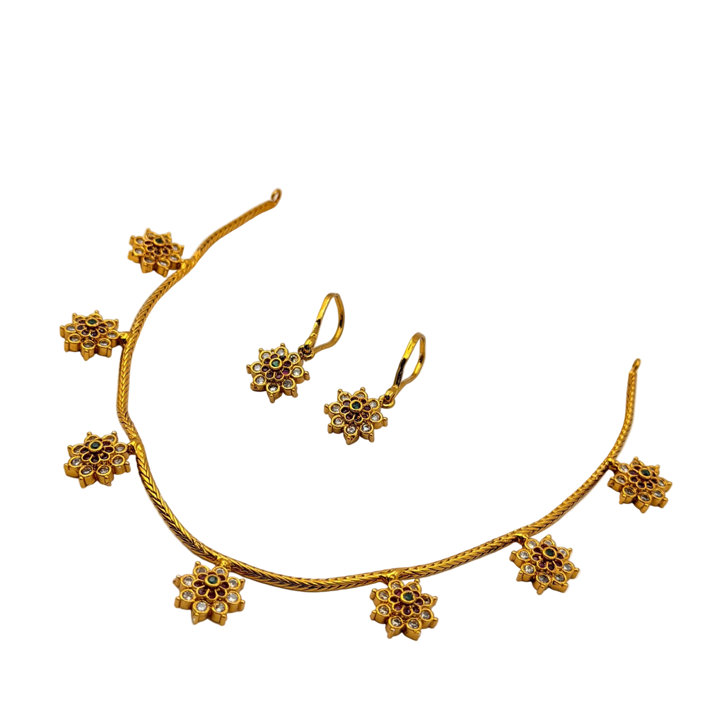 Gold necklace and earrings set on a white background