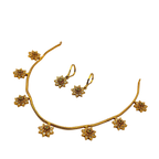 Gold necklace and earrings set on a white background