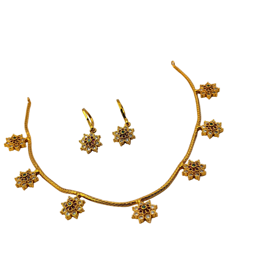 Gold necklace and earrings set on a white background
