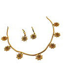 Gold necklace and earrings set on a white background
