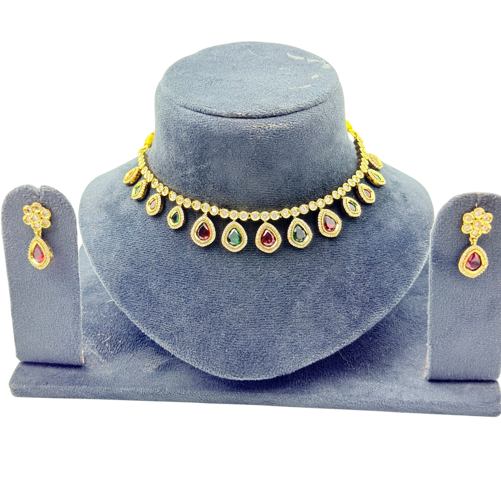 Jewelry set with necklace, earrings, and bangles on a blue velvet stand.