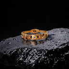 Gold bracelet with gemstones on a dark textured surface