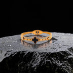Gold bracelet with black accents on a dark surface