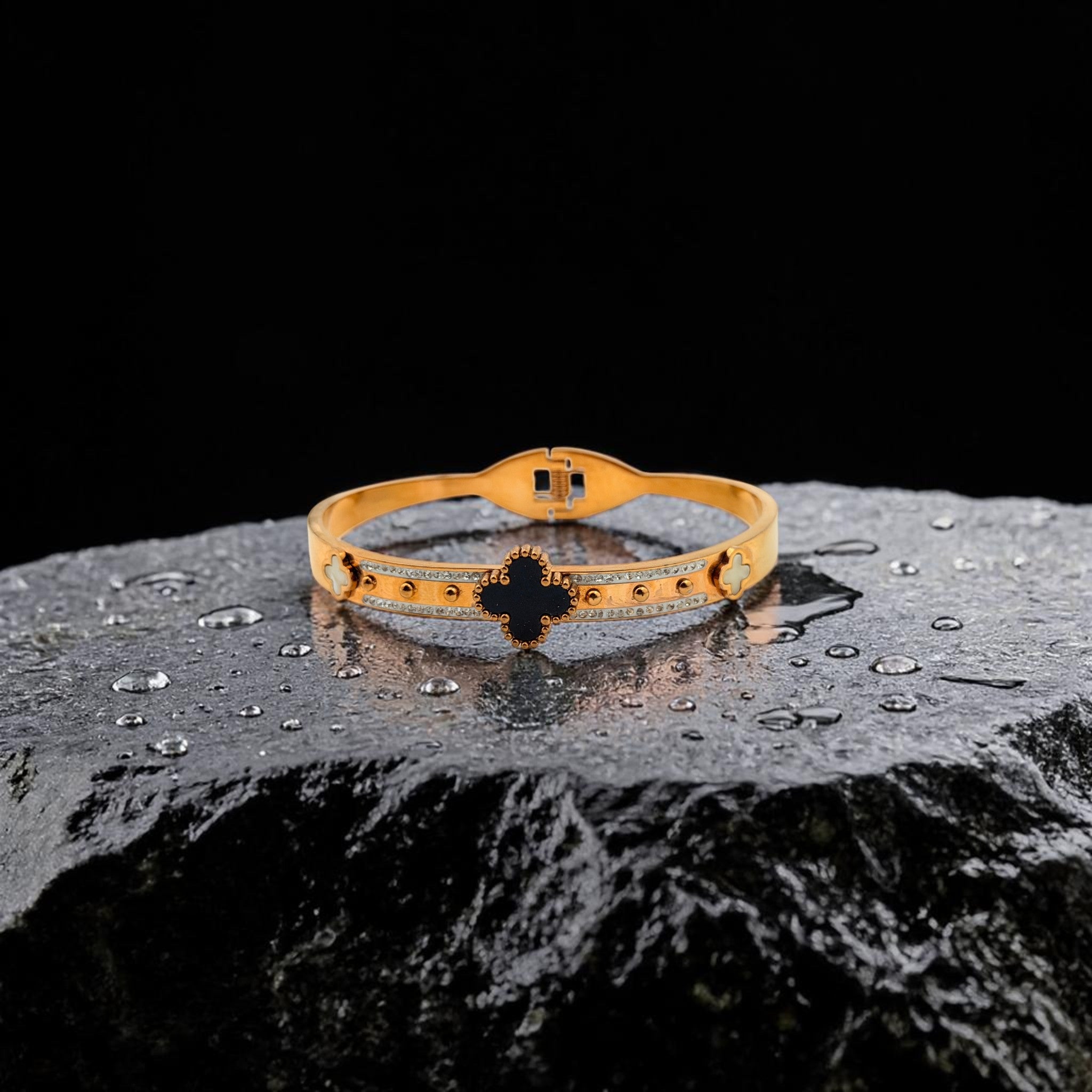 Gold bracelet with black accents on a dark surface
