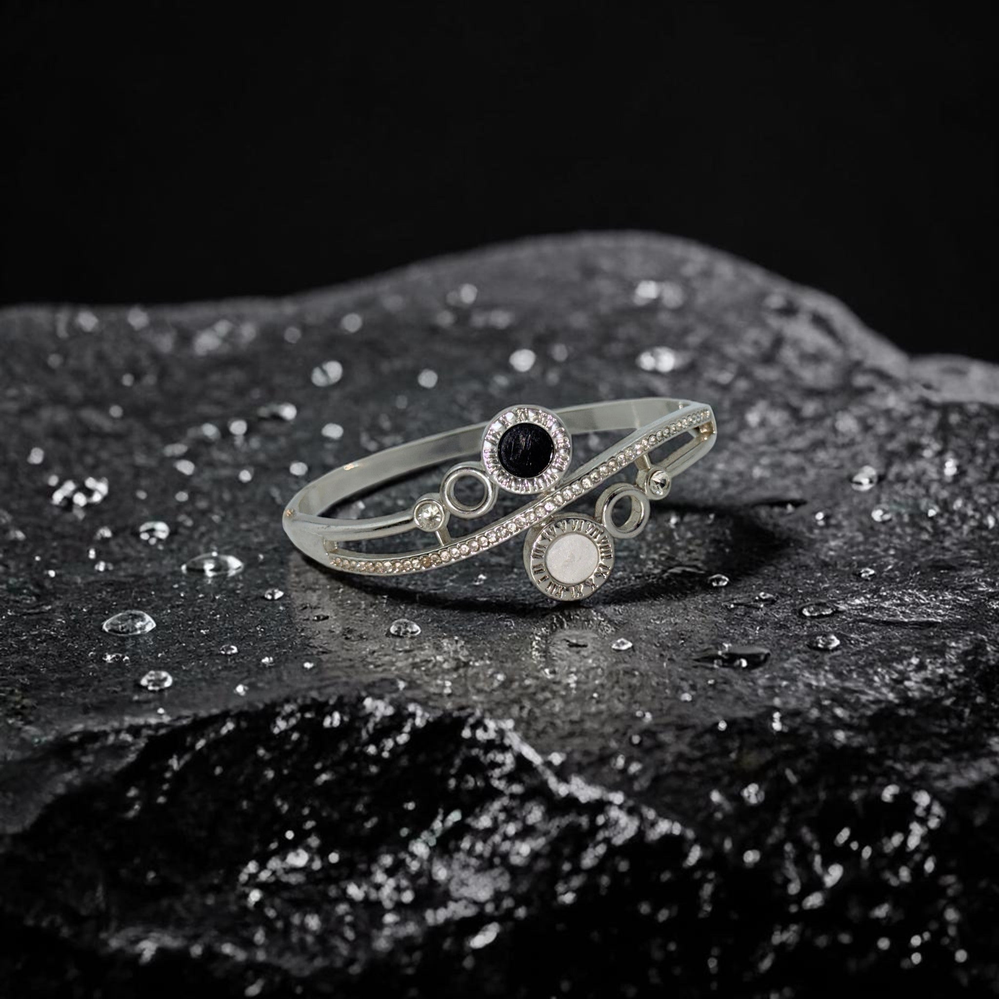 Silver bracelet with circular design on a dark textured surface