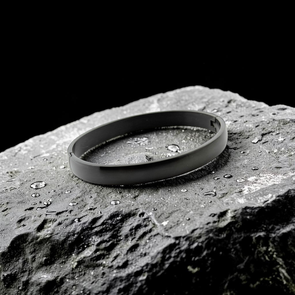 Black bracelet on a textured rock surface with water droplets