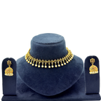 Gold necklace and earrings set on a blue velvet stand with a white background