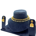 Gold necklace and earrings set on a blue stand with a white background