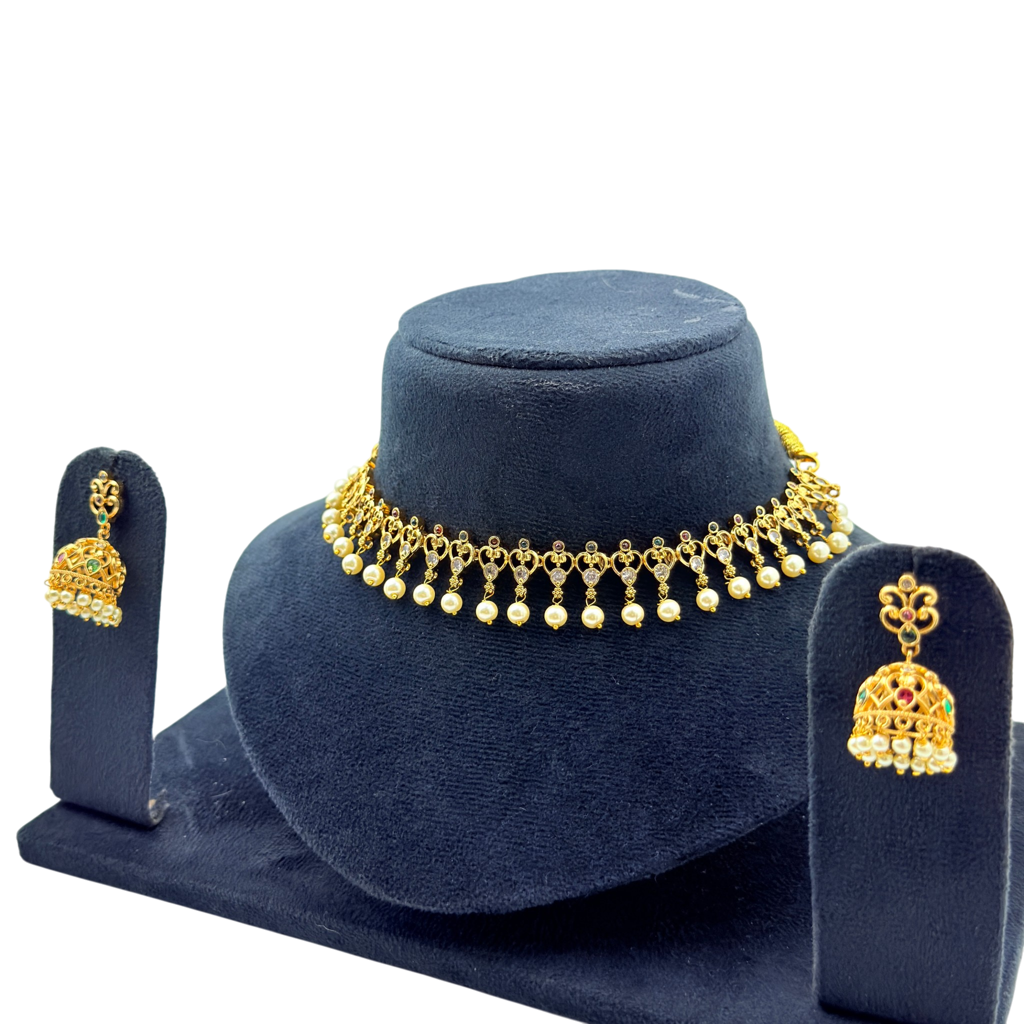 Gold necklace and earrings set on a blue stand with a white background