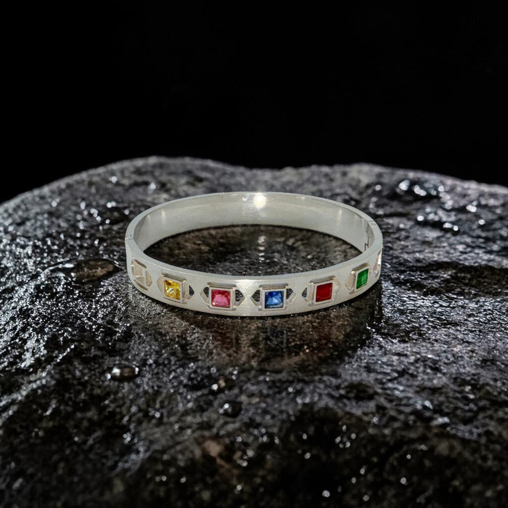 Silver bracelet with colorful gemstones on a dark textured surface