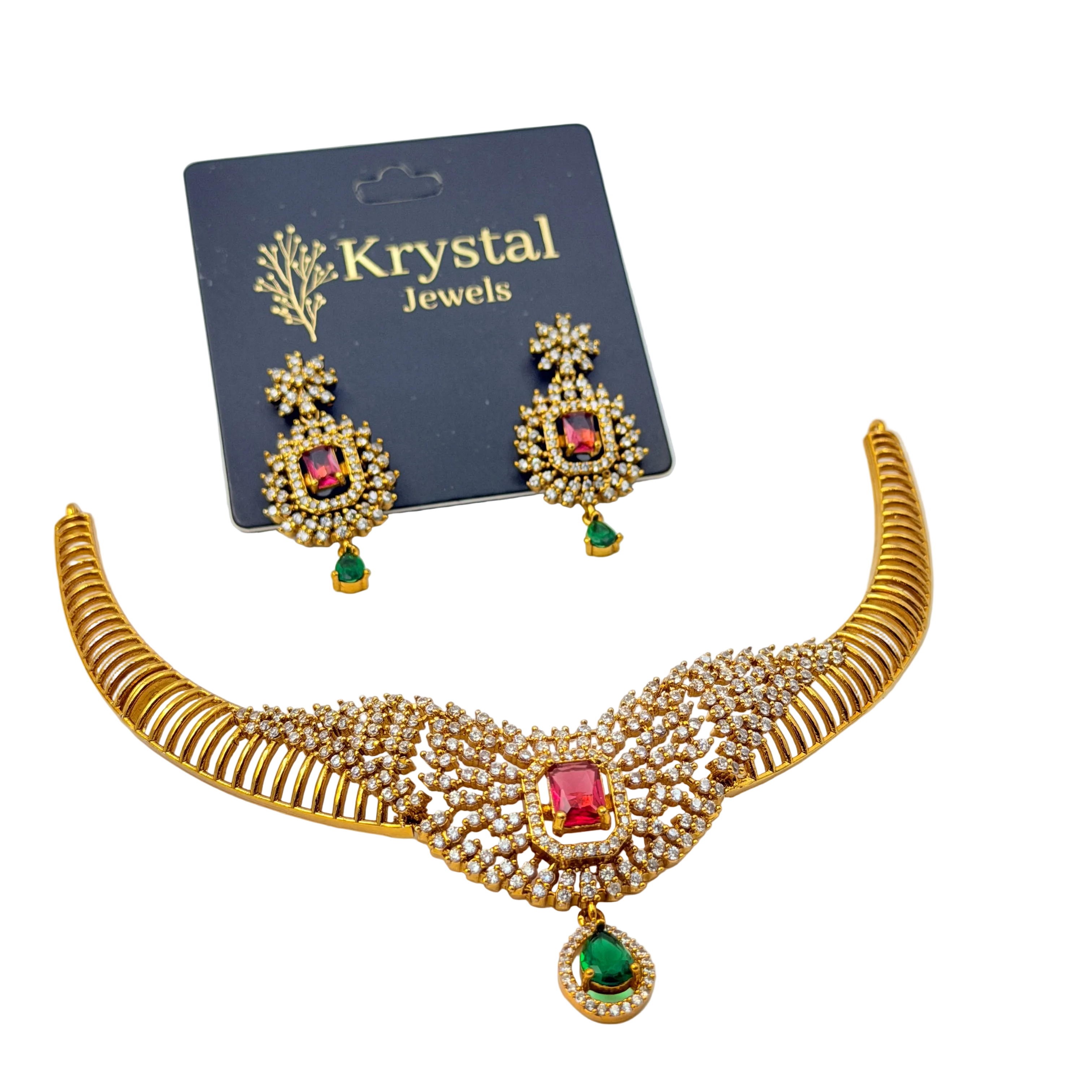 Woman wearing a gold necklace with red and green gemstones on a plain background