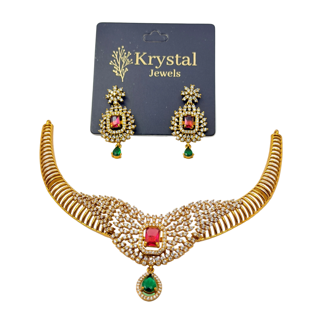 Gold necklace with red and green gemstones and matching earrings on a Krystal Jewels card.