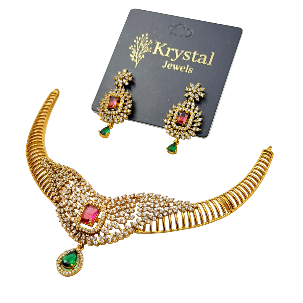 Gold necklace with red and green gemstones on a Krystal Jewels card