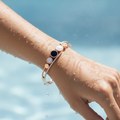 Hand wearing a bracelet with a blue background