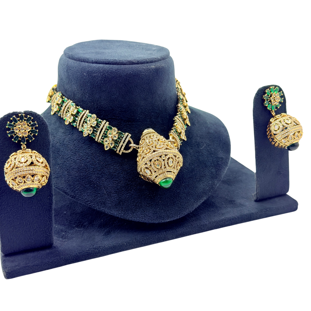 Gold and green jewelry set on a blue velvet stand