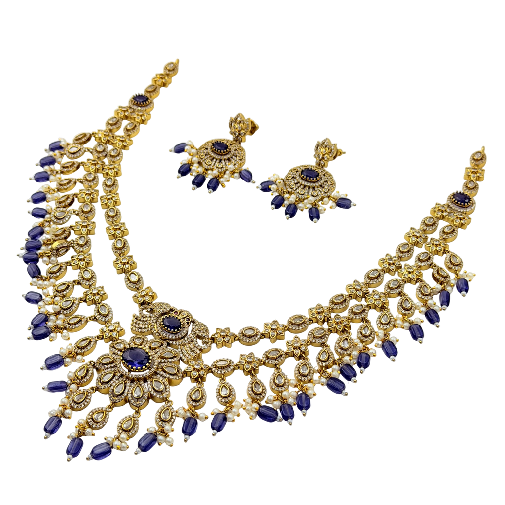 Gold and blue jewelry set on a white background