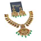 Gold necklace with green and red stones on a Krystal Jewels card