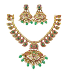 Gold necklace with green and red gemstones on a black background