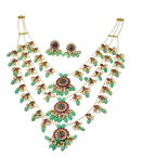 Ornate necklace with green and red gemstones on a white background