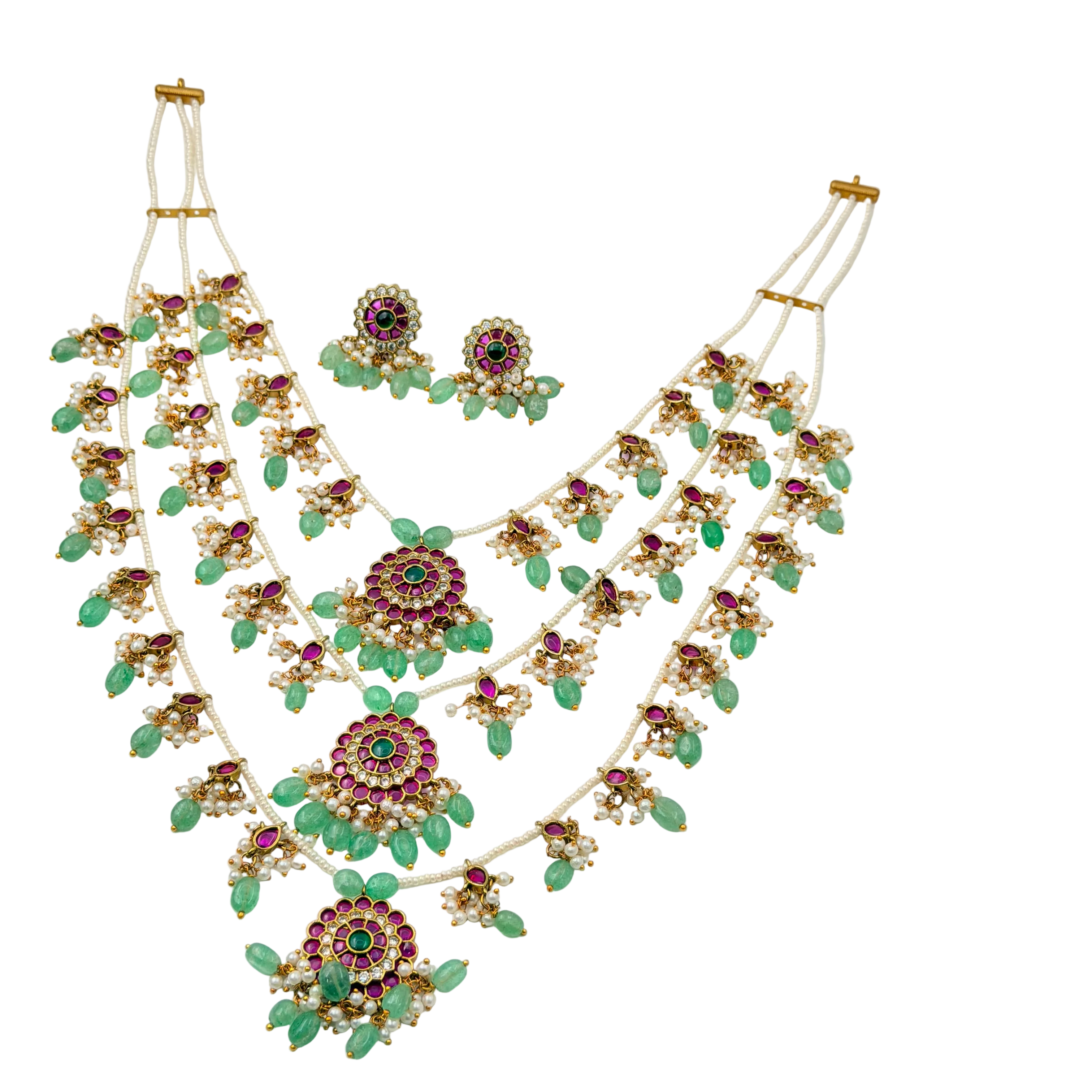Jewelry set with necklace and earrings featuring green stones and gold accents on a white background