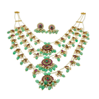 Ornate necklace and earrings set with green stones on a white background
