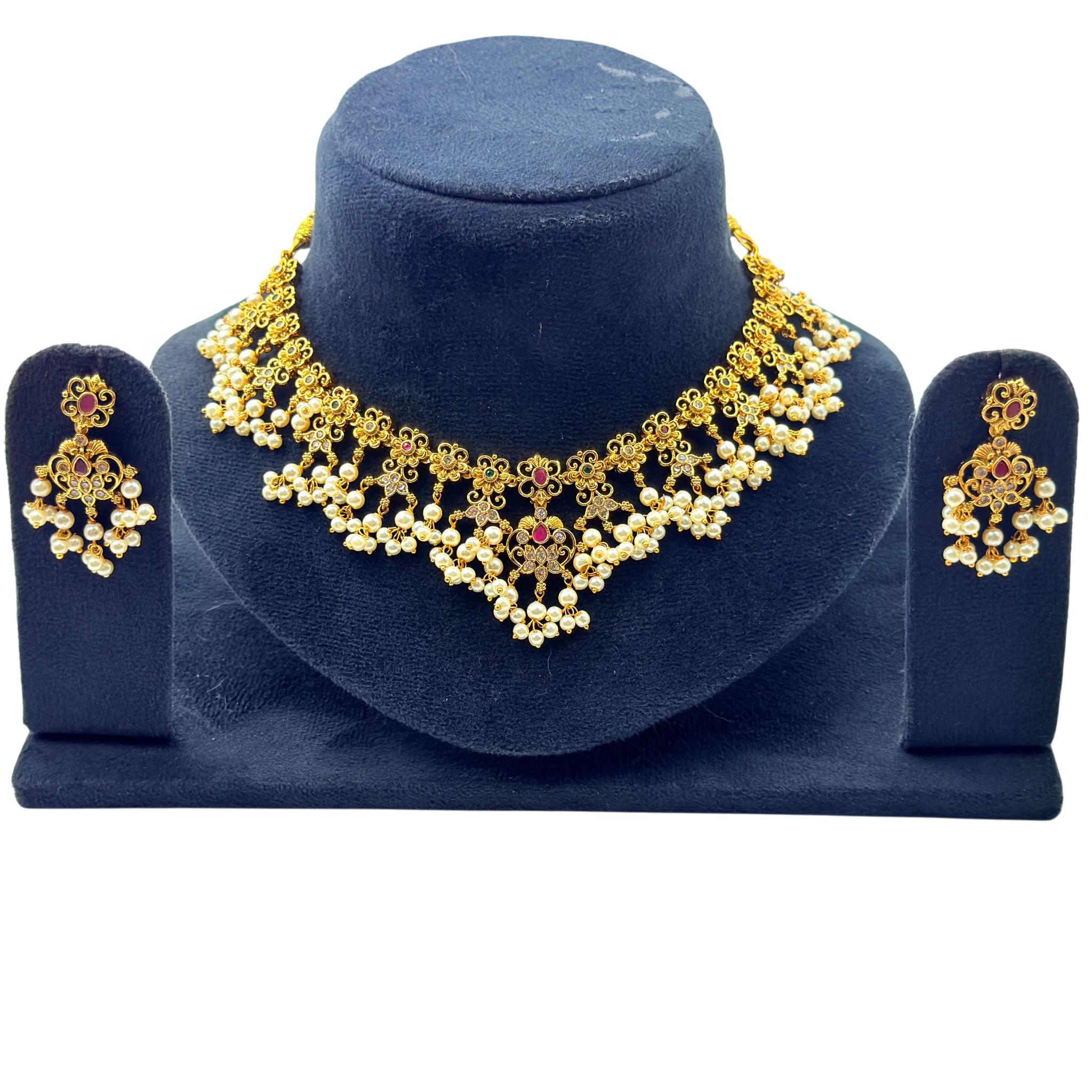 Gold necklace and earrings set on a blue stand with a white background