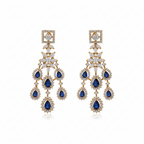 Gold-tone sapphire-blue chandelier drop earrings with CZ halo, flat-lay pair on white background