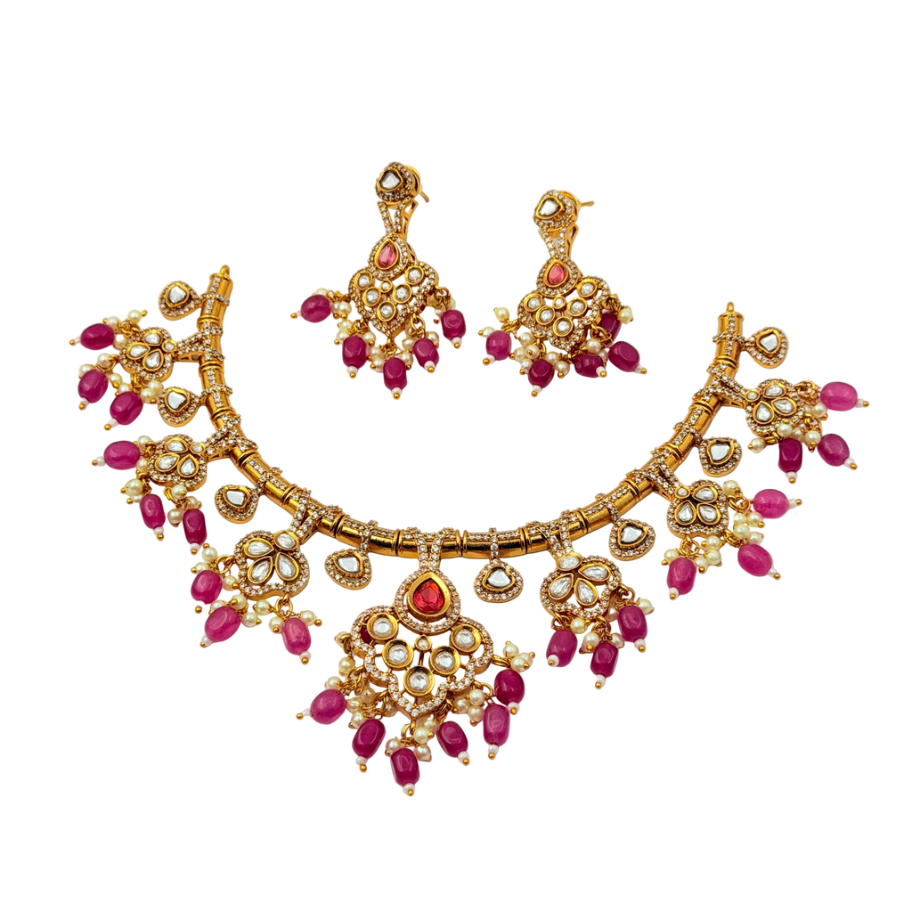 Gold necklace with pink gemstones on a white background