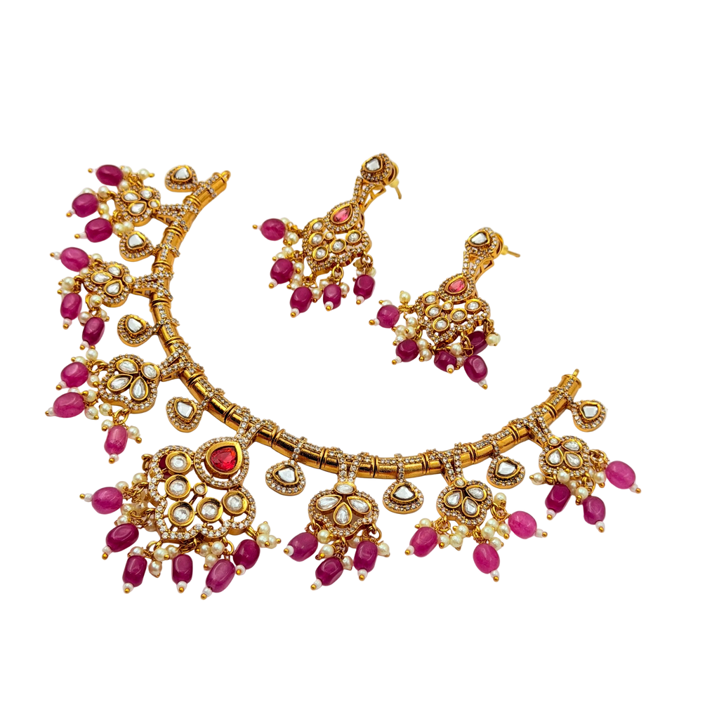 Gold necklace with pink stones on a white background