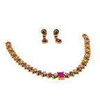 Gold necklace with pink and clear stones and matching earrings on a white background