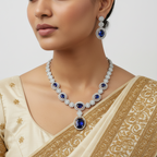 Woman wearing a luxurious diamond and sapphire necklace and earrings on a plain background