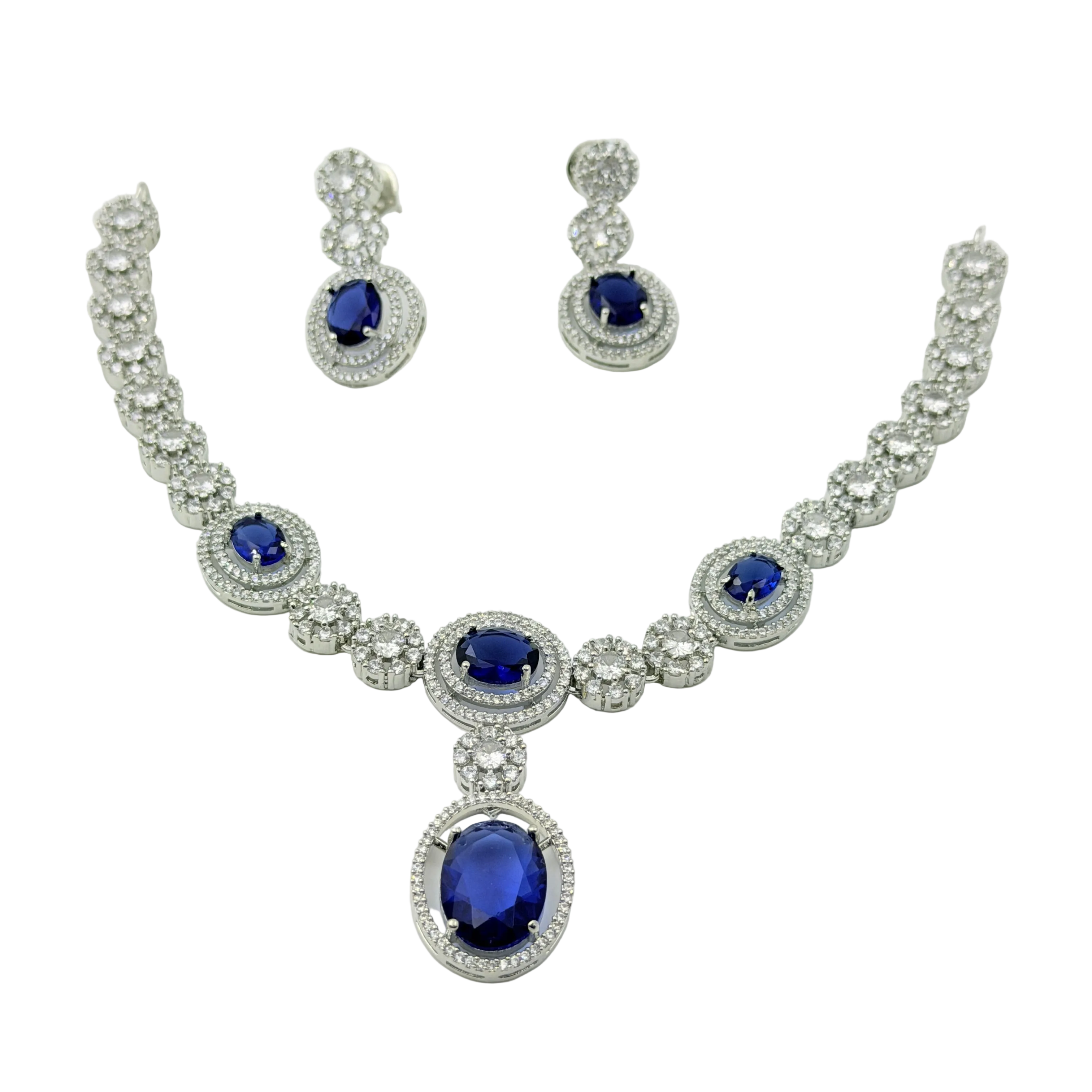 Jewelry set with necklace and earrings featuring blue gemstones on a white background