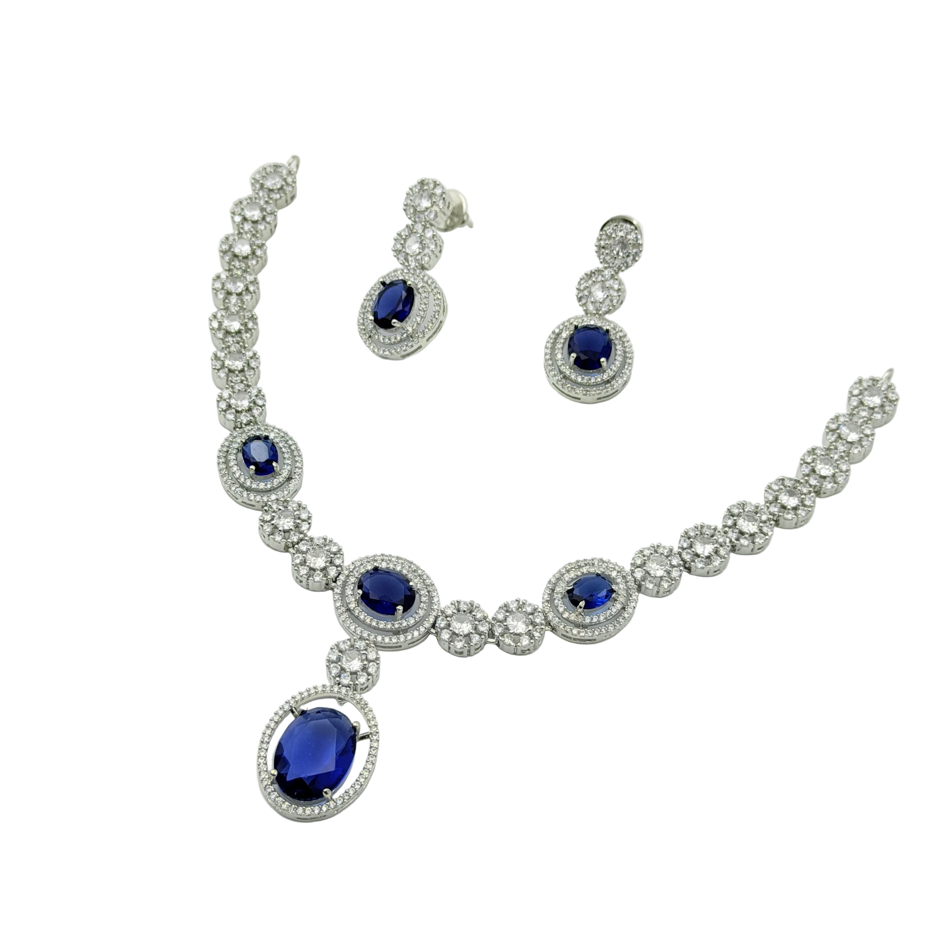 Jewelry set with necklace and earrings featuring blue gemstones on a white background
