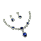 Jewelry set with necklace and earrings featuring blue gemstones on a white background