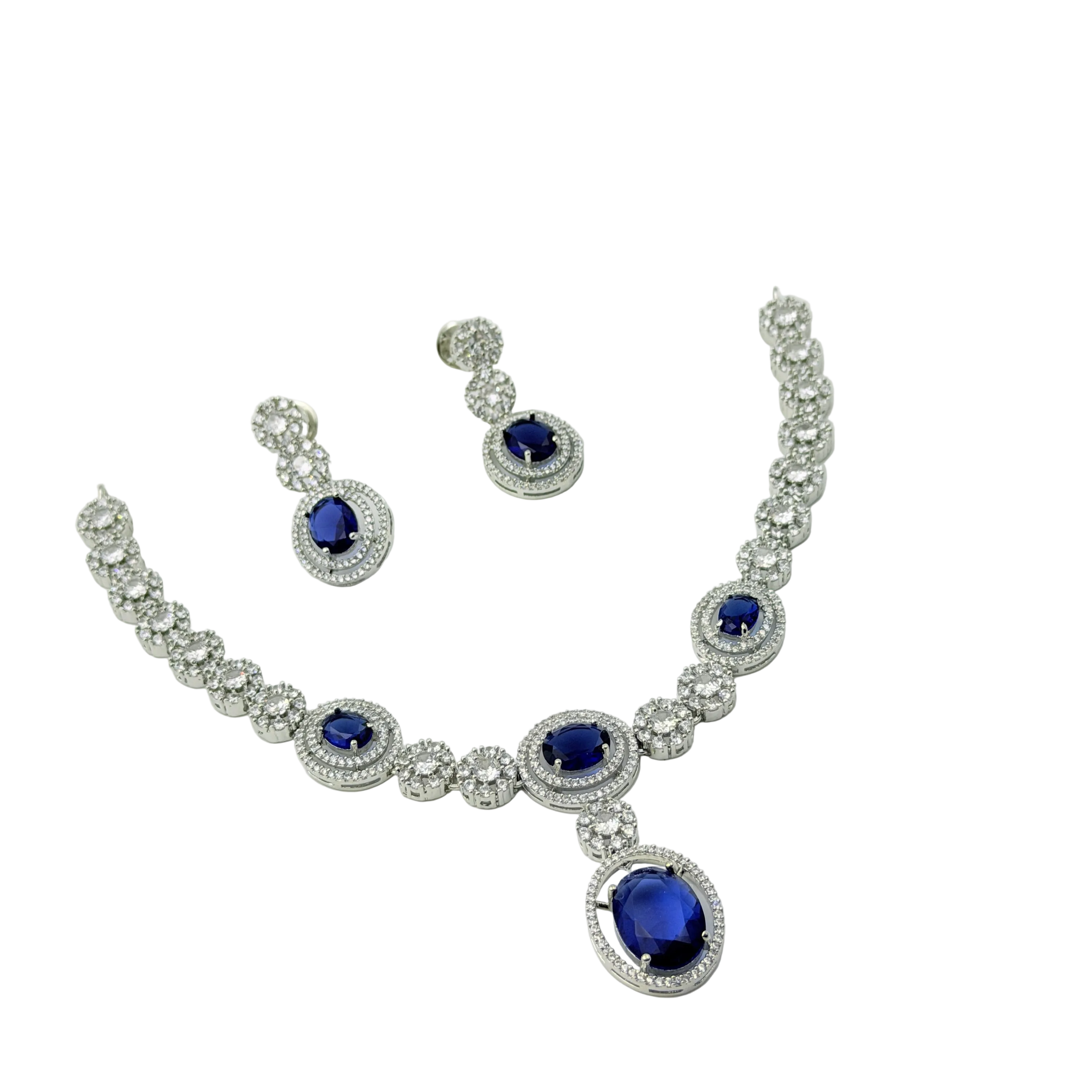 Jewelry set with necklace and earrings featuring blue gemstones on a white background